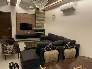 ラホールにあるRoyal Three-Bedroom Villa Dha Phase 6 Lahoreのソファとテーブルのあるリビングルーム