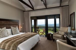 a bedroom with a large bed and a desk and chair at Intle Boutique Hotel in Jeffreys Bay