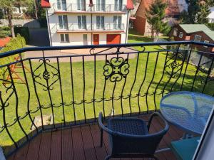 a balcony with two chairs and a fence with a yard at Willa u Anny in Mielno