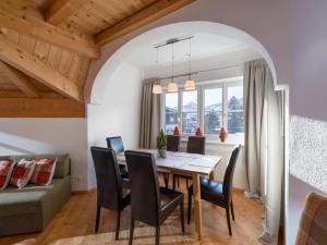 - une salle à manger avec une table, des chaises et un canapé dans l'établissement Alpen Glück Schlössl Unterm Rain, à Kirchberg in Tirol