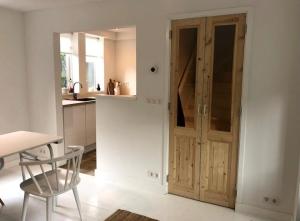 a kitchen with a wooden door and a chair at Klein Oldenburg in Bergen