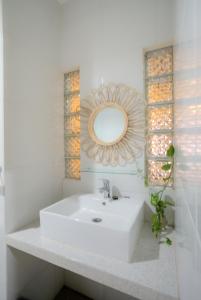 ein Badezimmer mit einem weißen Waschbecken und einem Spiegel in der Unterkunft Bata Merah Homestay in Banyuwangi + 88 Fotos