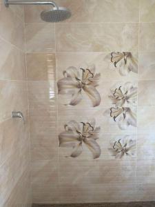 baño con ducha con flores en la pared en Elegant84, en Johannesburgo