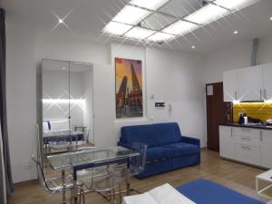 a living room with a blue couch and a glass table at Giudei House Loft 2 in Bologna
