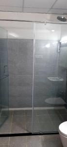a glass shower in a bathroom with a toilet at Hotel Agni in Krishnagiri