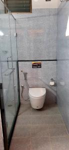 a bathroom with a toilet and a glass shower at Hotel Agni in Krishnagiri