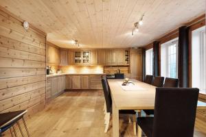 a kitchen and dining room with a wooden table and chairs at Kjerag Lodge in Tjørhom