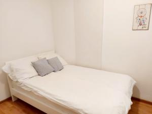 a white bed with two pillows on top of it at Red brick in Belgrade