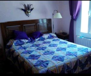 1 dormitorio con 1 cama con edredón azul en Casa Cascabelia. Cerca de Santillana del Mar en Valles