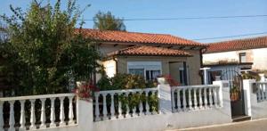 a white fence in front of a house at Casa Cascabelia. Cerca de Santillana del Mar in Valles