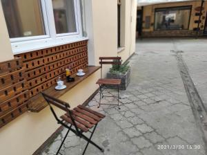 due sedie e un tavolo sul lato di un edificio di Retro Mini Apartment a Zemun