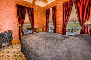 a bedroom with a large bed and red curtains at Irma Hotel in Cody