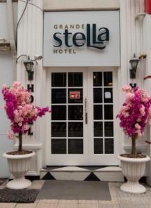 two white vases with pink flowers in front of a building at Grande Stella Hotel in Eskisehir