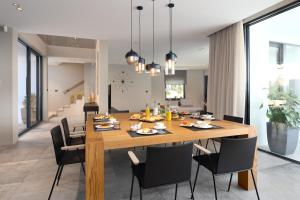 - une salle à manger et un salon avec une table et des chaises en bois dans l'établissement Luxury Villa Aruna, à Pula