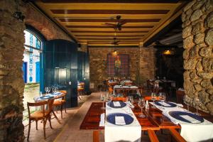 a restaurant with tables and chairs in a room at Pousada Bartholomeu in Paraty