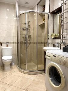 a bathroom with a shower and a washing machine at Apartment on Franka in Lviv