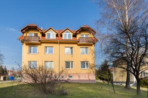 a yellow building with a roof on top of it at Apartman SEGATI in Slavičín