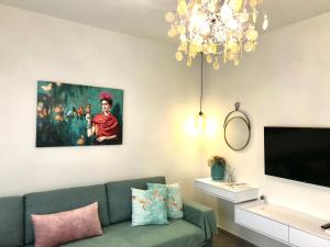 a living room with a green couch and a chandelier at Under the Aqueduct boutique house in Kavála