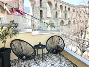 two chairs on a balcony with a view of the coliseum at Under the Aqueduct boutique house in Kavála