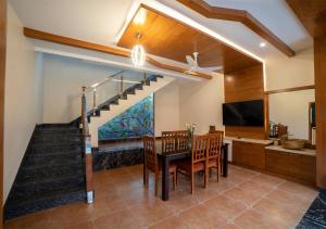 a dining room with a staircase and a table and chairs at SR Jungle Resort in Coimbatore