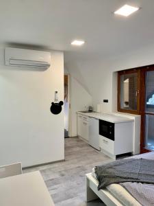 a white room with a kitchen and a bed at Vár-Lak Apartman in Eger