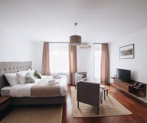 - une chambre avec un lit, une chaise et une télévision dans l'établissement Pegaz Holiday Resort, à Vrnjačka Banja