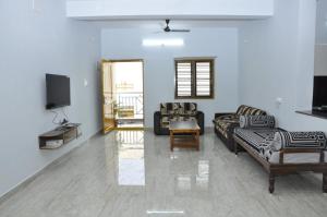 a living room with couches and a flat screen tv at Maanas Homestay in Tirupati