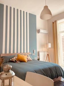 a bedroom with a bed with a striped wall at Casa Antonietta in San Paolo Bel Sito