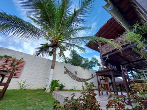a palm tree in front of a building with a house at Pousada Brisa Del Mar in Icaraí