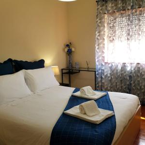 a bedroom with a bed with two towels and a window at B Apartamentos in Viana do Castelo