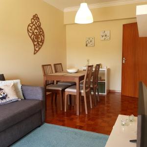 sala de estar con mesa, sillas y sofá en B Apartamentos en Viana do Castelo