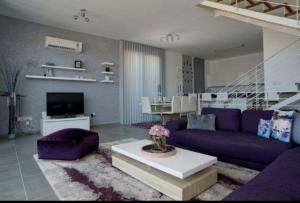 a living room with a purple couch and a table at Leonidas VILLA in Paphos