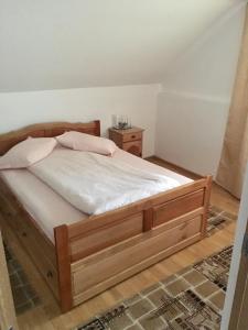 a bedroom with a bed with a wooden frame at Cabana Baraj Apuseni Mountains in Mihoeşti