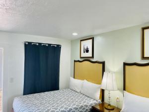a bedroom with a bed and a blue curtain at Siesta Inn Sarasota - Indian Beach in Sarasota