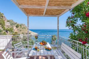 a table on a balcony with a view of the ocean at Paradisea Taormina in Taormina