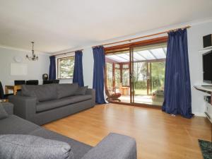 a living room with blue curtains and a couch at Three Jays in Looe