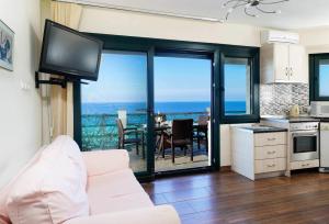 - un salon avec un canapé et une vue sur l'océan dans l'établissement Giotas Sea View Apartment, à Skala Kallirakhis