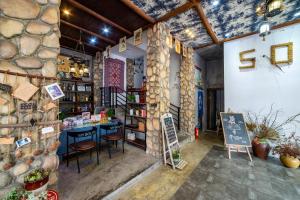 un negozio con bancone e sedie in una stanza di Zhangjiajie Highlights Guesthouse a Zhangjiajie