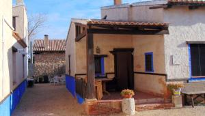 un edificio con porche con mesa y sillas en Casas Rurales Lagunas de Ruidera - Piscina, en Ossa de Montiel
