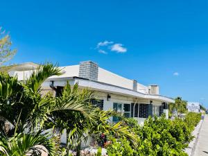 a white house with plants in front of it at Siesta Inn Sarasota - Indian Beach in Sarasota