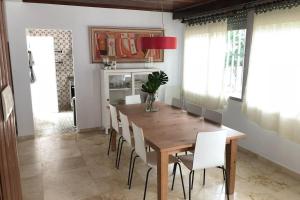 a dining room with a wooden table and white chairs at Casa en plena naturaleza al lado del rio Verdugo in Arcade