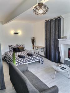 a living room with a bed and a couch at Studio ZEN Tout Confort Proche Hyper-Centre in Cognac