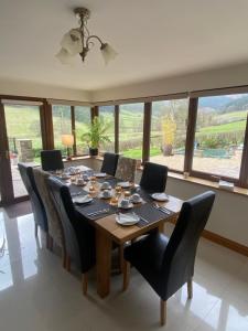 a dining room with a wooden table and chairs at Laurel Bank in Abbey-Cwmhir