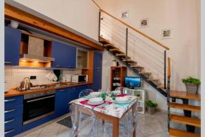 una cocina con armarios azules, una mesa y una escalera en Stella Marina 6, en Venecia