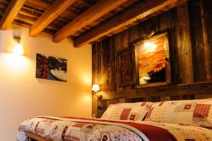 a bedroom with a bed with a wooden wall at Clé du Paradis in Bionaz