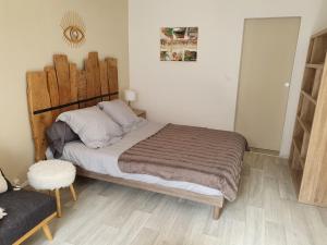 Un dormitorio con una cama con cabecero de madera. en studio vllage, en Entrecasteaux