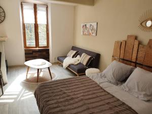 Un dormitorio con una cama, un sofá y una mesa. en studio vllage, en Entrecasteaux