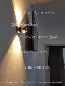 una lámpara colgada en una pared junto a un espejo en Yelay Apartments & Holiday Lago di Garda, en Raffa