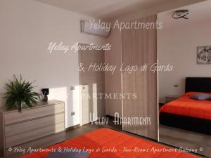 1 dormitorio con 1 cama y pared de cristal en Yelay Apartments & Holiday Lago di Garda, en Raffa