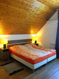 een bed in een kamer met een houten plafond bij Balatonföldvár Centrum Apartmanok in Balatonföldvár